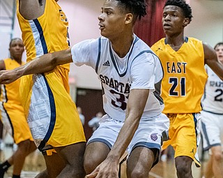 DIANNA OATRIDGE | THE VINDICATOR  Boardman's Daeone Martin (31) drives around Youngstown East's Deland Richardson (3) as Marquan Gilmer (21) looks on during their game at Boardman High School Friday night.