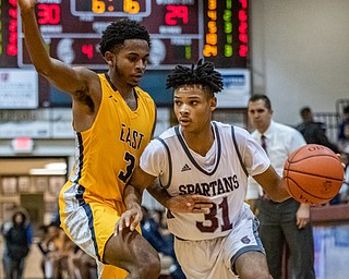 DIANNA OATRIDGE | THE VINDICATOR  Boardman's Daeone Martin (31) drives around Youngstown East's Deland Richardson (3) during their game at Boardman High School Friday night.