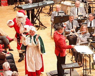 Santa greets the crowd with Mrs. Claus while The Packard Band plays Here Comes Santa Claus during The Packard Band annual Christmas Spectacular at W.D. Packard Music Hall on Sunday afternoon. EMILY MATTHEWS | THE VINDICATOR