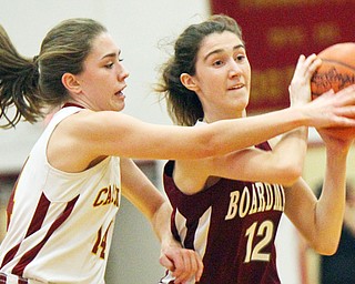 Camden Hergenrother, left, of Cardinal Mooney High School, defends against Boardman High School's Bailey Moore during Monday night's action at Mooney. The Cardinals downed the Lady Spartans 60-46.