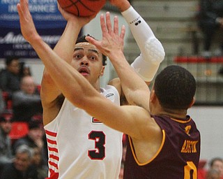 William D. Lewis the Vindicator  YSU's Darius Quisenberry(3) shoots around CMU's Larry Austin Jr(0) during 12-4-18 action at YSU.