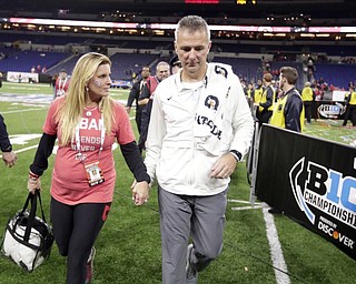  Ohio State head coach Urban Meyer walks off the field with his wife, Shelley Meyer, on Sunday.