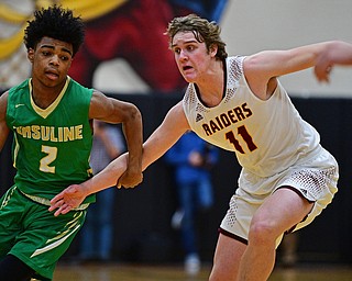 CANFIELD, OHIO - DECEMBER 4, 2018: Ursuline's Daysean Harris drives on South Range's Dante DiGaetano during the first half of their game, Tuesday night at South Range High School. DAVID DERMER | THE VINDICATOR