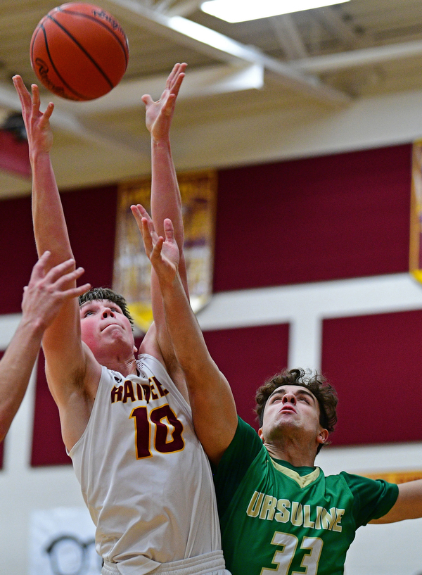 CANFIELD, OHIO - DECEMBER 4, 2018: South Range's Chris Brooks grabs a rebound away from Ursuline's Luke Pipala during the first half of their game, Tuesday night at South Range High School. DAVID DERMER | THE VINDICATOR