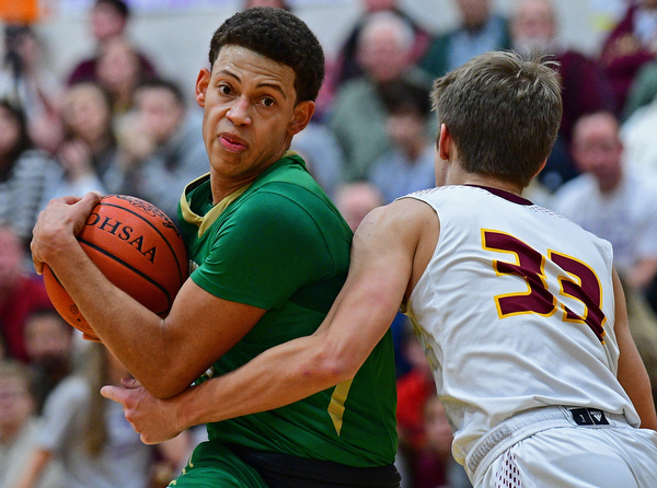 CANFIELD, OHIO - DECEMBER 4, 2018: Ursuline's Devan Keevy drives while being fouled by South Range's Ben Irons during the first half of their game, Tuesday night at South Range High School. DAVID DERMER | THE VINDICATOR