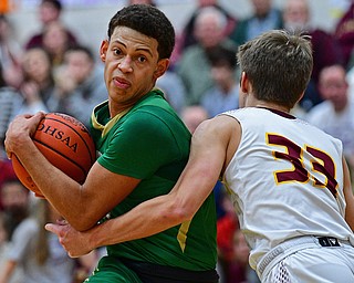 CANFIELD, OHIO - DECEMBER 4, 2018: Ursuline's Devan Keevy drives while being fouled by South Range's Ben Irons during the first half of their game, Tuesday night at South Range High School. DAVID DERMER | THE VINDICATOR