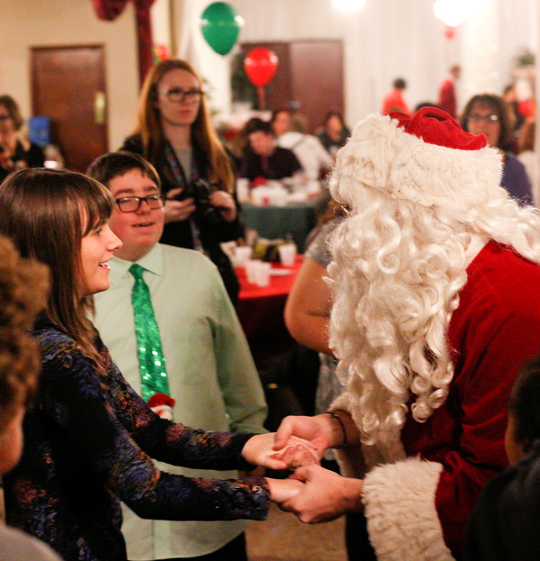 Katelyn Hall, 16, a student at Fitch High School, dances with Santa at the 18th annual Winterfest dance at The Mahoning Country Club on Wednesday night. EMILY MATTHEWS | THE VINDICATOR