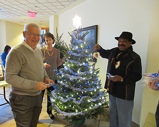 Neighbors | Jessica Harker.Dave Scott, Caren Barr and Art Harris are pictured hanging ornaments depicting the faces of Meals on Wheel volunteers and employees on a tree at Mill Creek Park's Fellows Riverside Garden on Nov. 27.