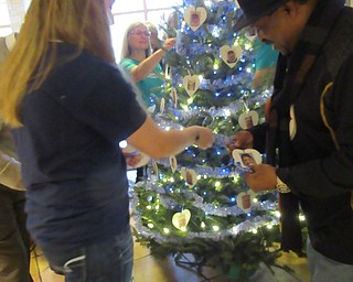 Neighbors | Jessica Harker.Brittany Bailing and Art Harris from Meals on Wheels put hand made ornaments on a tree in Fellows Riverside Garden as part of the Frozen in Time event hosted by Mill Creek Park.