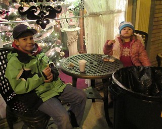 Neighbors | Jessica Harker.Ashton and Hadley Temey sat outside Piccadilly Parlor eating cookies on Nov. 30 for Canfield's annual Lighting of the Green event.