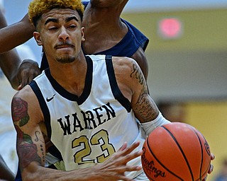 WARREN, OHIO - DECEMBER 6, 2018: Warren Harding's Dom McGhee looks to pass the ball while being pressured from behind by Cleveland Heights' Ronald Davis during the first half of their game Thursday night at Warren Harding High School. DAVID DERMER | THE VINDICATOR