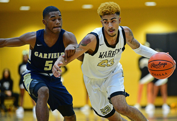 WARREN, OHIO - DECEMBER 6, 2018: Warren Harding's Dom McGhee drives on Cleveland Heights' Ronald Davis during the first half of their game Thursday night at Warren Harding High School. DAVID DERMER | THE VINDICATOR