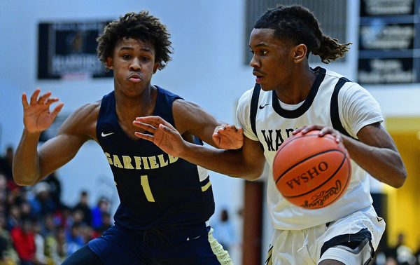 WARREN, OHIO - DECEMBER 6, 2018: Warren Harding's D'Muntize Owens drives on Cleveland Heights' Meechie Johnson during the first half of their game Thursday night at Warren Harding High School. DAVID DERMER | THE VINDICATOR