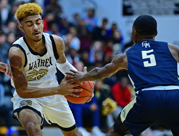 WARREN, OHIO - DECEMBER 6, 2018: Warren Harding's Dom McGhee protects the ball from Cleveland Heights' Ronald Davis during the first half of their game Thursday night at Warren Harding High School. DAVID DERMER | THE VINDICATOR