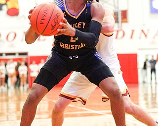 Valley Christian's Jordan Trowers looks to pass the ball while Cardinal Mooney's Sonny Rodriguez tries to block him during the second period of their game at Cardinal Mooney on Friday night. EMILY MATTHEWS | THE VINDICATOR