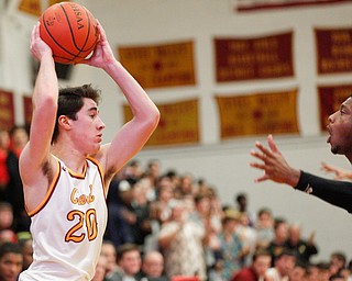 Cardinal Mooney's Matt Brennan looks to pass the ball while Valley Christian's Jordan Trowers tries to block him during the first period of their game at Cardinal Mooney on Friday night. EMILY MATTHEWS | THE VINDICATOR