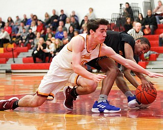 Cardinal Mooney's Matt Brennan reaches for the ball as Valley Christian's Mark Revere grabs it during the first period of their game at Cardinal Mooney on Friday night. EMILY MATTHEWS | THE VINDICATOR