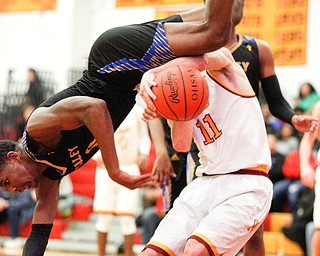 Valley Christian's Melvin Neail falls over Cardinal Mooney's Anthony Fire as he goes for the ball during the first period of their game at Cardinal Mooney on Friday night. EMILY MATTHEWS | THE VINDICATOR