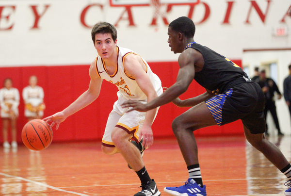 Cardinal Mooney's Anthony Fire looks to pass the ball as he tries to get past Valley Christian's Damon Christian during the second period of their game at Cardinal Mooney on Friday night. EMILY MATTHEWS | THE VINDICATOR