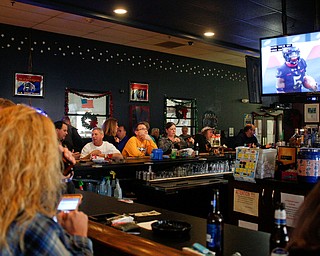 People watch the Army vs. Navy football game at the Farrell VFW 5286 on Saturday afternoon. Frank Zelinsky, who organized the second annual watch party, said he wants the VFW to be the place for community members to come together to watch the Army and Navy game every year. EMILY MATTHEWS | THE VINDICATOR