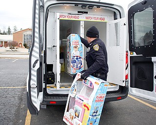 Youngstown Police Officer Michael Bodnar puts toys in a police van at Youngstown Police Department's fourth annual fill a cruiser campaign in the St. Christine Church parking lot on Saturday afternoon. EMILY MATTHEWS | THE VINDICATOR