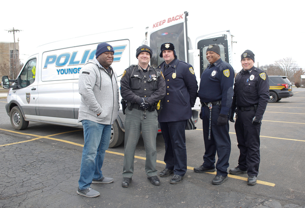 From left, Youngstown Police Officer George Wallace, Deputy Kirk Mines, Lt. Frank Rutherford, Officer Melvin Johnson, and Officer Michael Bodnar pose in front of a police van they were filling with toys at Youngstown Police Department's fourth annual fill a cruiser campaign in the St. Christine Church parking lot on Saturday afternoon. EMILY MATTHEWS | THE VINDICATOR