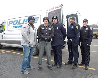 From left, Youngstown Police Officer George Wallace, Deputy Kirk Mines, Lt. Frank Rutherford, Officer Melvin Johnson, and Officer Michael Bodnar pose in front of a police van they were filling with toys at Youngstown Police Department's fourth annual fill a cruiser campaign in the St. Christine Church parking lot on Saturday afternoon. EMILY MATTHEWS | THE VINDICATOR