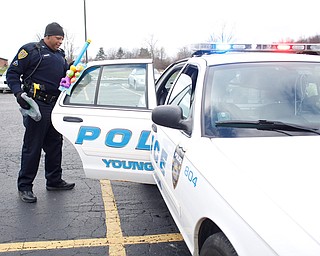 Officer Melvin Johnson puts toys in his police car at Youngstown Police Department's fourth annual fill a cruiser campaign in the St. Christine Church parking lot on Saturday afternoon. EMILY MATTHEWS | THE VINDICATOR