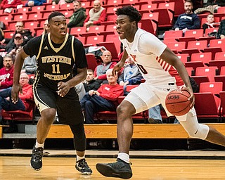 DIANNA OATRIDGE | THE VINDICATOR  Youngstown State's Antwan Maxwell (0) drives the baseline against defensive pressure by Western Michigan's Kawanise Wilkins (11) during their game at Beeghly Center on Saturday.