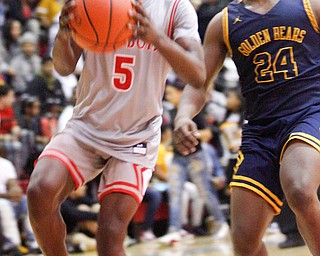 Chaney's Cameron Lawrence looks to the hoop with East's Jarail Jenkins close behind him during their game at Chaney High School on Tuesday night. EMILY MATTHEWS | THE VINDICATOR