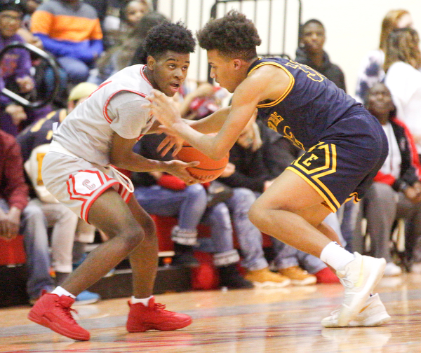 Chaney's Ryan Clark looks to pass the ball while East's Dasan Dupree tries to block him during their game at Chaney High School on Tuesday night. EMILY MATTHEWS | THE VINDICATOR