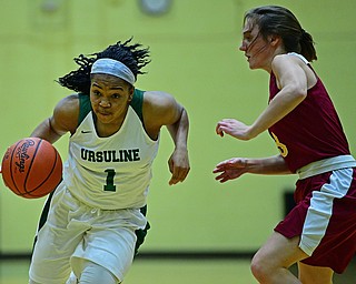 YOUNGSTOWN, OHIO - DECEMBER 12, 2018: Ursuline's Dayshanette Harris drives on Mooney's Cameryn Olesh during the first half of their game, Wednesday night at Ursuline High School. DAVID DERMER | THE VINDICATOR