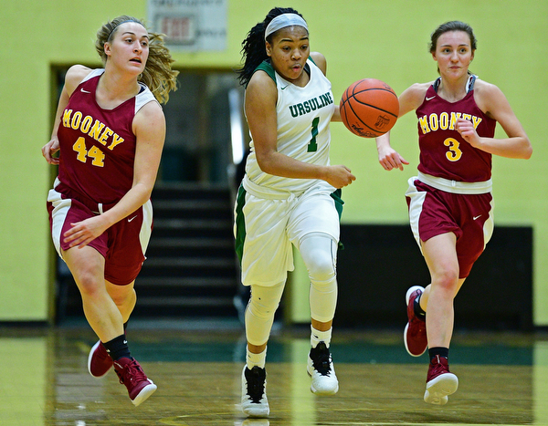 YOUNGSTOWN, OHIO - DECEMBER 12, 2018: Ursuline's Dayshanette Harris dribbles between Mooney's Caitlin Perry, left, and Cameryn Olesh during the first half of their game, Wednesday night at Ursuline High School. DAVID DERMER | THE VINDICATOR