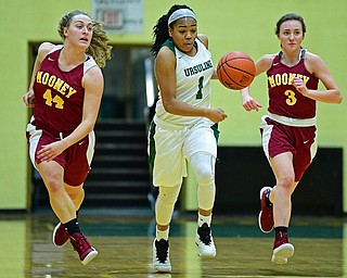YOUNGSTOWN, OHIO - DECEMBER 12, 2018: Ursuline's Dayshanette Harris dribbles between Mooney's Caitlin Perry, left, and Cameryn Olesh during the first half of their game, Wednesday night at Ursuline High School. DAVID DERMER | THE VINDICATOR