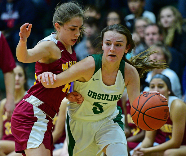 YOUNGSTOWN, OHIO - DECEMBER 12, 2018: Ursuline's Cara McNally drives on Mooney's Camden Hergenrother during the first half of their game, Wednesday night at Ursuline High School. DAVID DERMER | THE VINDICATOR