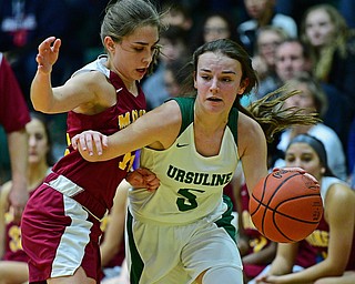 YOUNGSTOWN, OHIO - DECEMBER 12, 2018: Ursuline's Cara McNally drives on Mooney's Camden Hergenrother during the first half of their game, Wednesday night at Ursuline High School. DAVID DERMER | THE VINDICATOR