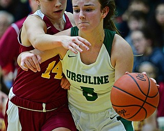 YOUNGSTOWN, OHIO - DECEMBER 12, 2018: Ursuline's Cara McNally drives on Mooney's Camden Hergenrother during the first half of their game, Wednesday night at Ursuline High School. DAVID DERMER | THE VINDICATOR