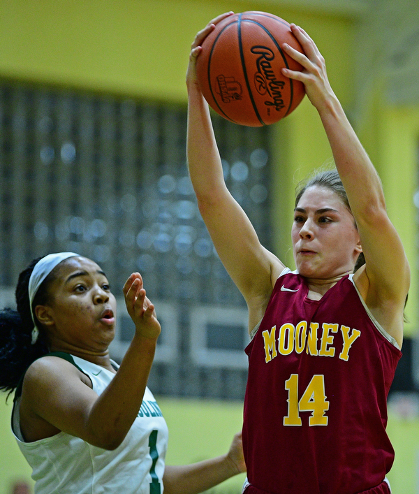 YOUNGSTOWN, OHIO - DECEMBER 12, 2018: Mooney's Camden Hergenrother grabs a rebound away from Ursuline's Dayshanette Harris during the first half of their game, Wednesday night at Ursuline High School. DAVID DERMER | THE VINDICATOR