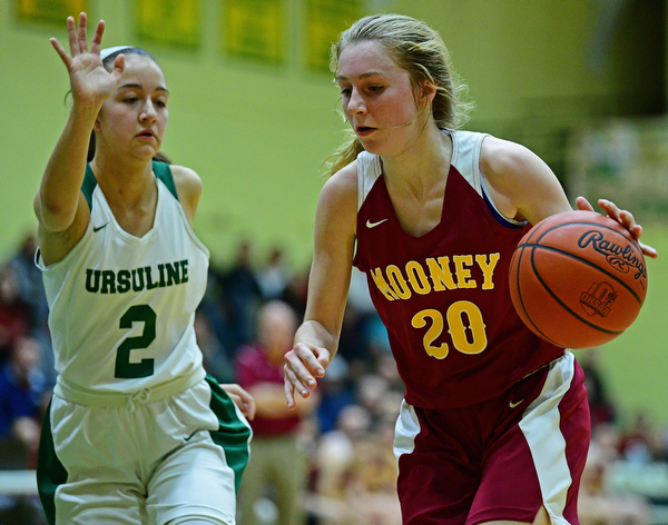 YOUNGSTOWN, OHIO - DECEMBER 12, 2018: Mooney's Katie Hough drives on Ursuline's Rachel Fabry during the first half of their game, Wednesday night at Ursuline High School. DAVID DERMER | THE VINDICATOR