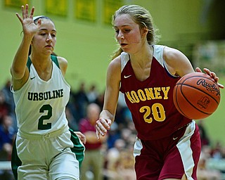 YOUNGSTOWN, OHIO - DECEMBER 12, 2018: Mooney's Katie Hough drives on Ursuline's Rachel Fabry during the first half of their game, Wednesday night at Ursuline High School. DAVID DERMER | THE VINDICATOR