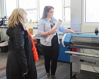 Neighbors | Jessica Harker .Hannah Matulek, a librarian at the Michael Kusalaba library, loaded the vinyl printer during the libraries Simple Sticker event Nov. 30.