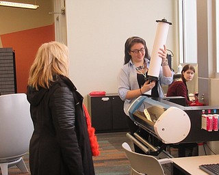 Neighbors | Jessica Harker .Librarian Hannah Matulek loaded paper into the vinyl printer at the Michael Kusalaba library on Nov. 30 for the simple sticker event.