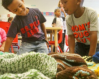 William D. Lewis The vindicator  Wilson preschoolers Jose Feliciano, left, and Kam Allison check out winter hats that were donated to them.