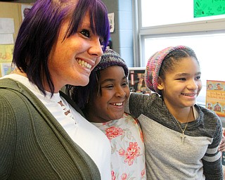 William D. Lewis The vindicator  Wilson 4th graders Nahjae Page, left, and Lamya Fleeton, right, don winter hats that were donated to them while talking with their teacher Courtney Angelo. They are classmates of girl who died in house fire.