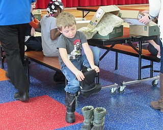 Neighbors | Jessica Harker.Kenneth Miller was one of 650 students locally to receive a new pair of boots from Making Kids Count on Dec. 3 at AES.