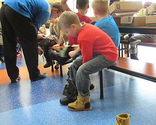 Neighbors | Jessica Harker.Daniel Kern tried on his new boots from Making Kids Count Dec. 3 at Austintown Elementary School.