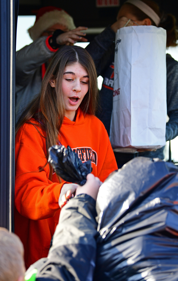 COLUMBIANA, OHIO - DECEMBER 13, 2018: Abigail Hawkins, a 7th grader at Springfield, is handed a bag of gifts by a classmate, Thursday morning in Columbiana. DAVID DERMER | THE VINDICATOR