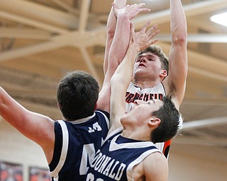 Springfield's Evan Ohlin grabs the ball McDonald's Jake Portolese, left, and Dominic Carkido reach for it during their game at Springfield on Friday night. EMILY MATTHEWS | THE VINDICATOR