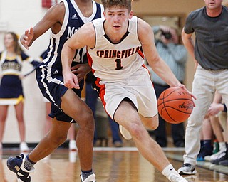 Springfield's Evan Ohlin dribbles the ball with McDonald's Cam Tucker close behind him during their game at Springfield on Friday night. EMILY MATTHEWS | THE VINDICATOR