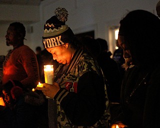 Shirley Martinez, of Youngstown, bows her head in prayer during a vigil for the five children who died in a fire last week at Christ Centered Church on Saturday evening. Martinez said she knows the victims' mother and grandmother from working with them at the Things Remembered warehouse in North Jackson. EMILY MATTHEWS | THE VINDICATOR